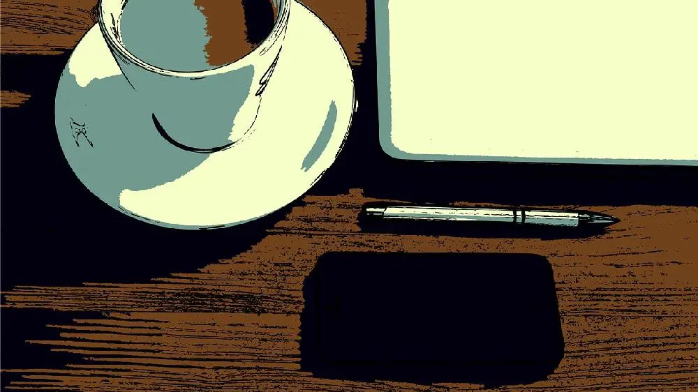 彼女の机の上に置かれた黒いiphoneとコーヒーカップとノートPC